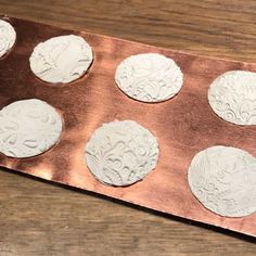 a metal tray with six white cookies in it on top of a wooden table next to a cupcake tin