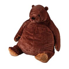 a large brown teddy bear sitting up against a white background