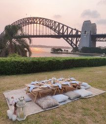 a picnic set up in front of the sydney harbour bridge