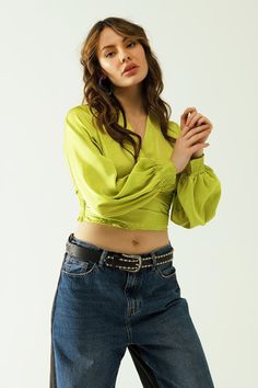 Introducing our Short Green Crop Top with Long and Wide Sleeves – a sophisticated and stylish choice for your next party. This crop top features a V-neck neckline, long sleeves, and a standard fit, creating a chic and trendy look.  Crafted from luxurious satin, this top adds an elegant touch to your ensemble. The wrap design and fitted waist accentuate your figure, providing a flattering and fashionable silhouette. The zip side ensures a secure fit while adding a sleek detail to the overall design.  Made from 100% Polyester, the top offers a soft and smooth feel against your skin. For sizing reference, the model is wearing size S, with measurements 33-25-35 and a height of 5'7''. It's important to note that this top runs small, so it's recommended to size up. The S-M-L sizing corresponds t Crop Top Corto, Top Verde, Tan Scarf, Green Crop Top, Sleeves Style, Wrap Crop Tops, Style Party, Running Tops, Tailored Trousers