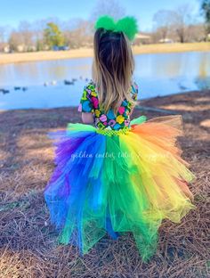 This high low tutu is next level. The front is an Ombre green and topped with a shiny gold bow. The back is over 100 yards of tulle with tiered layers creating a wild rainbow look. The back layers have glitter tulle mixed in. Sizing Info: 1-3T is roughly 6" long in the front, 20" long in the back 4-5T is roughly 8 inches long in the front, 25" long in the back 6-8 years is roughly 10 long in the front, 30" long in the back Whimsical Green Tutu Dress For Dress-up, Fitted Multicolor Tutu Dress With Ruffles, Tiered Tutu Dress For Dress-up, Tiered Fitted Tutu Dress For Dress-up, Fitted Glitter Tulle Tutu Dress For Summer, Spring Rainbow Tutu Dress With Ruffles, Playful Multicolor Tulle Tutu Dress, Multicolor Playful Tulle Tutu Dress, Playful Rainbow Tutu Dress For Spring