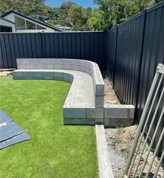 a backyard with artificial grass and fenced in area