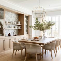 a dining room table with chairs and plates on it