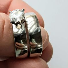 two silver rings with a white diamond in them