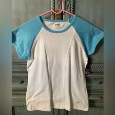 T-Shirt With Aqua Cap Sleeves And White Body. The Shirt Has A Round Neckline Piped In Aqua. Cotton Raglan Sleeve Sports Top, Cotton Raglan Sleeve Top For Sports, Body Color, Body Colour, The Shirt, Round Neckline, Cap Sleeves, Color White, Womens Tops