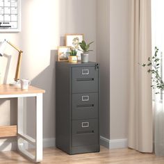 a filing cabinet in the corner of a room next to a desk with a potted plant on it