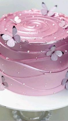 there is a pink cake with butterflies on it