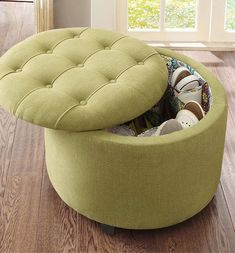 a green ottoman that is on top of a hard wood floor in front of a window