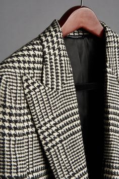 Our Prince of Wales coating fabric is a pure heavy duty wool woven in England. Weighing in at a beefy 19oz, this coat has a substantial hand and drape. Its key characteristic is the classic “prince of wales” (or “glenplaid”) pattern rendered in black and white yarns. This is a beautiful, timeless coat that makes a style statement but is also extremely versatile. Dress it up or dress it down, with everything from tuxedos to jeans. Every outfit will be a stunner with this coat. Thank us later. Luxury Tailored Houndstooth Outerwear, Wool Double-breasted Houndstooth Outerwear, Double-breasted Wool Houndstooth Outerwear, Black Wool Blazer With Houndstooth Pattern, Elegant Houndstooth Outerwear For Tailoring, Elegant Wool Houndstooth Outerwear, Wool Outerwear With Houndstooth Pattern And Suit Collar, Luxury Houndstooth Outerwear For Winter, Luxury Houndstooth Winter Outerwear