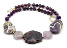 A natural gemstone necklace crafted with large chunks of purple amethyst, lavender amethyst and faceted golden pyrite. LENGTH:  18.8  inches -  48 cm Amethyst chunks: 35 x 28 mm max Lavender amethyst: 20 mm Round amethyst: 8 mm Pyrite: 4 mm MATERIALS: Amethyst: Used to cultivate spiritual growth, clear the mind, and dispel negative energy, Amethyst's properties provide a helping hand to anyone seeking for guidance, understanding and wisdom. Amethyst is the birthstone for February and is connecte Amethyst Properties, Natural Gemstone Necklace, Birthday Gift For Women, Necklace Purple, Statement Choker, Necklace Craft, February Birthstone, Gemstone Jewellery, Crown Chakra