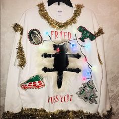 a white sweater with an image of a black cat on it and christmas lights around the neck