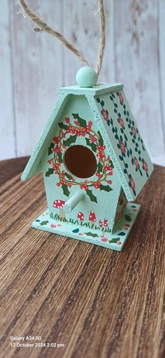 a small birdhouse with flowers painted on it