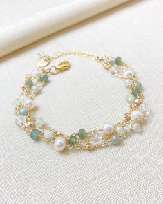 Embrace the beauty of nature and the luxury of timeless elegance with this exquisite bracelet. Three delicate layers of green apatite, prehnite, crystal quartz, and freshwater pearls create a sublime palette set in gold fill. Each tiny gemstone and pearl is carefully hand-wired for a delicate yet sturdy design you will enjoy for years. Length: 7 inches plus 1-inch extender Materials: gold fill, green apatite, prehnite, crystal quartz, cultured freshwater pearls The matching necklace: https://www Luxury Gold Crystal Gemstone Bracelet, Luxury Green Gemstone Beaded Bracelets, Luxury Elegant Crystal Bracelet With Gemstone Beads, Luxury Green Elegant Chain Bracelet, Luxury Handmade Delicate Jewelry, Luxury Gemstone Beaded Bracelets For Weddings, Luxury Pearl Bracelet With Natural Stones, Luxury Delicate Gemstone Beads Jewelry, Luxury Elegant Pearl Bracelet With Gemstone