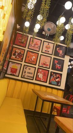 the inside of a restaurant with posters on the wall and tables in front of it