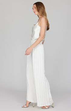 A wide leg pant featuring dramatic pleating at the sides. This pant moves beautifully as you walk and is an unexpected way to do special occasion. Finished with a back zip to maintain a clean front, this pant pairs perfectly with a matching camisole or layered with the pleat back collared shirt. Elegant Pleated Wide Leg Pants For Summer, Elegant Straight Leg Wedding Bottoms, Elegant White Bottoms With Accordion Pleats, Elegant Bottoms With Accordion Pleats For Night Out, Elegant Accordion Pleated Bottoms For Night Out, Sleek Wide Leg Pants For Evening And Spring, Elegant Spring Pleated Wide Leg Pants, Sleek Wide Leg Pants For Evening In Spring, Sleek Evening Wide Leg Pants For Spring