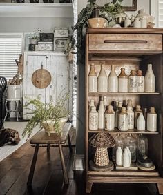 a wooden cabinet filled with lots of bottles and jars on top of a hard wood floor