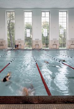 an indoor swimming pool with people in it