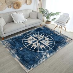 a living room area rug with a compass design on the floor and white furniture in the background