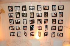 a room with pictures on the wall and candles in front of it, decorated with flowers