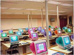 rows of desks with computers on them in a classroom