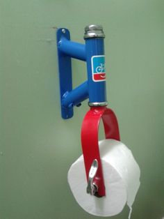 a toilet paper dispenser attached to the wall with a red and blue handle