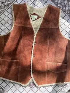 Beautiful '70s classic Western suede vest, with metal snap buttons, sherpa lining, visible stitching throughout the front, two outer pockets and the sweetest little inside pocket. ꩜Label: made in Mexico ꩜Condition: great vintage condition, gently worn. Some wear on suede on shoulder areas and a small rip on the suede near the right-side pocket. Please see close-up photos. ꩜Material: outer is genuine leather, lining is polyester (sherpa) ꩜Sizing: Fits M-L best, men's XS-S. Please check measuremen Western Brown, Visible Stitching, Suede Vest, Vest Outfits, Perfectly Imperfect, Vintage 1970s, 1970s, Genuine Leather, Bathing Beauties