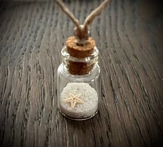 a small glass bottle filled with sand and starfish