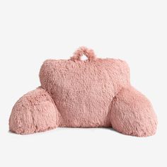 a pink teddy bear pillow sitting on top of it's back and the rest of its body