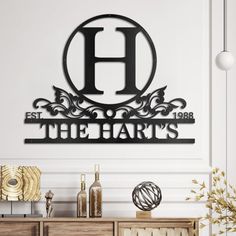 a metal sign that says the harts on it's sideboard in front of a white wall