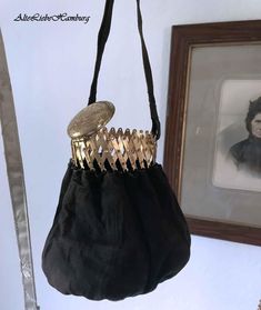 Elegant evening bag with a metal frame closure that opens like a scissor gate. The black handle bag probably dates from the 1930s. The closure has a beautifully decorated lid that closes the scissor gate. Dimensions: Approx. 16 cm high / approx. 14 cm diameter Black Victorian Bag For Vintage Events, Victorian Style Black Bag For Vintage Events, Vintage Evening Coin Purse Pouch, Vintage Black Pouch Evening Bag, Black Victorian Style Bags For Formal Occasions, Black Victorian Style Formal Bag, Vintage Black Handheld Evening Bag, Antique Style Clutch For Vintage Events, Antique Clutch Evening Bag For Vintage Events