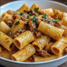 a white bowl filled with pasta and meat