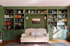 a living room with bookshelves and a couch in front of the bookcases