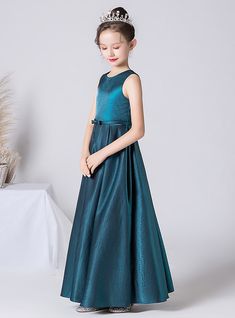 Of the elegant options available, this beautiful teal flower girl dress is sure to impress. The dress features a shimmering satin fabric that catches the light with every movement, ensuring your flower girl stands out at any event. The sleeveless design provides a contemporary and stylish look, while the full-length skirt flows gracefully, creating a stunning silhouette. A delicate bow at the waist adds a refined touch, enhancing the dress's overall charm and sophistication. Made from high-quali Satin Dress For Kids, Long Flower Girl Dresses, Neck Flower, One Shoulder Prom Dress, Green Tulle, Satin Long Sleeve, Full Length Skirts, Black Prom Dress, Girl Standing