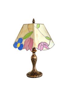 a lamp that is sitting on top of a white surface with a flower design on it