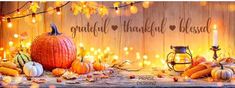 pumpkins and corn on a wooden table with lights around them that say, grateful thanksgiving biscuit