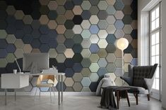 a room with a chair, desk and computer monitor on the wall that has hexagonal tiles all over it