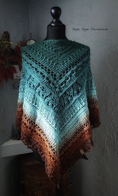 a crocheted shawl draped over a mannequin