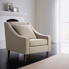 a beige chair sitting in front of a fireplace