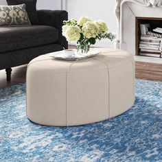 a living room with a couch, chair and coffee table on top of a blue rug