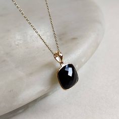 ITEM DESCRIPTION: >>The pendant is made from Solid 14K Yellow Gold. Gemstone used is absolutely natural and ethically sourced. >>Natural Black Onyx in checker cut and cushion shape with bezel setting is studded on it with utmost precision. >>This is a minimalist design and is absolutely hassle-free and everyday jewelry. Gem: Black Onyx Gem size: 12x12 mm Gem weight: 6.68 carats Gold purity: 14K (58.33% approx.) Gold weight: 0.59 grams Gross weight: 1.93 grams The Gold purity is guaranteed and it Gold Onyx Pendant Jewelry, Black Onyx Pendant, Luxury Onyx Round Pendant Jewelry, 14k Gold Square Pendant With Gemstone, Onyx Pendant Necklace With Polished Finish, Bezel Pendant, Square Pendant, December Birthstone, Gold Pendant Necklace