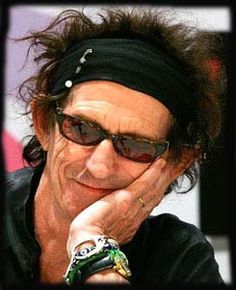 a man wearing sunglasses and a headband with his hands on his face while looking at the camera