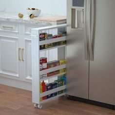 a white refrigerator freezer sitting inside of a kitchen next to a counter with food on it