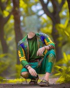 a man sitting on the ground in front of some trees