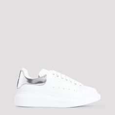 Alexander McQueen White Leather Sneakers. Pure white leather sneakers, round toe, top lace-up fastening, silver-tone printed logo on the tongue, perforated details on the upper, silver tone detail on the heel, back white logo on the heel, white rubber sole. Silver Low-top Sneakers With Contrast Sole, Silver Sneakers With Perforated Toe Box, Silver Leather Sneakers With Contrast Sole, Silver High-top Sneakers With Perforations, Modern Silver Sneakers With Rubber Sole, Modern Silver Sneakers With Laces, Modern Silver Sneakers With Metallic Logo, Luxury Silver Sneakers With Metallic Logo, Classic Silver High-top Sneakers