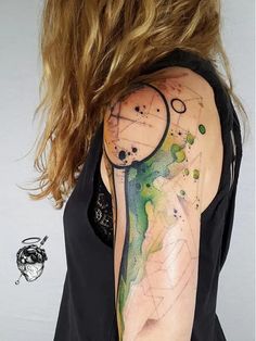 a woman's arm with a clock on it and some watercolors in the background