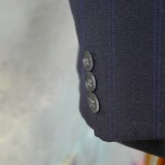 "This navy blue double-breasted blazer has notch lapels and padded shoulders, and closes in the front with one button (four in total show on the front). Three buttons decorate each sleeve cuff. The dark blue wool-blend jacket has three pockets on the front, and is fully lined in a navy blue satin viscose fabric (with two inner pockets). The fabric has a double pinstripe pattern, with a textured chevron herringbone running vertically as well. Brand label: Turo (Made in Finland) Size: 40 US/UK Mat Striped Fitted Double Breasted Suit With Double Button, Tailored Pinstripe Suits With Double-breasted Button Fastening, Fitted Striped Double Breasted Suit With Double Button Closure, Striped Blazer With Double Button Closure And Notch Lapel, Striped Notch Lapel Blazer With Double Button Closure, Blue Double-breasted Suits For Business Casual, Double-breasted Pinstripe Fitted Blazer, Fitted Pinstripe Double-breasted Blazer, Striped Blazer With Double Button Closure For Tailoring