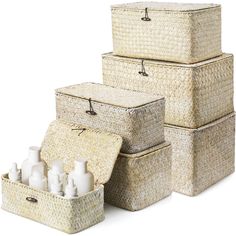 three wicker storage baskets with bottles and soaps in them on a white background