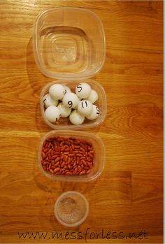 three plastic containers filled with food on top of a wooden table next to a coin