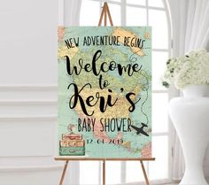 a welcome sign for a baby shower is displayed in front of a window with flowers