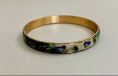 "Fabulous bangle by Taiwanese artist Robert Kuo, brings an organic, modern look to an ancient art. Cool colors of blue, green, purple and cream enamel surround stylized leaves and hearts outlined in gold. Just gorgeous and quite unusual.  Bracelet measures 2 5/8\" inside diameter and 8\" circumference. Listing is offered as-is. Please ask any questions prior to purchasing." Elegant Hand Painted Bracelet, Wearable Art Green Bangle Jewelry, Hand Painted Gold Bracelet, Gold Hand Painted Bracelets As Gift, Gold Hand Painted Bracelets For Gift, Hand Painted Gold Bracelets For Gift, Artistic Hand Painted Jewelry Bracelet, Hand Painted Gold Jewelry Wearable Art, Heart Outline